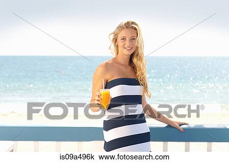 Woman drinking orange juice outdoors View Large Photo Image Stock Image - Woman drinking orange juice outdoors. Fotosearch