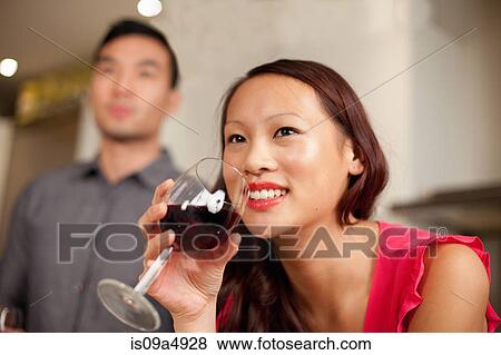 Stock Photo - Woman drinking wine in kitchen. Fotosearch