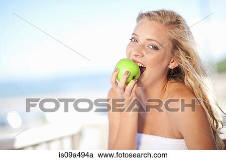 Woman eating apple outdoors View Large Photo Image Stock Image - Woman eating apple outdoors. Fotosearch