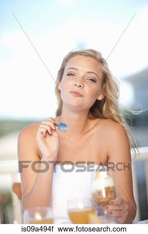 Stock Image - Woman eating breakfast outdoors. Fotosearch