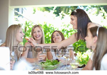 Woman feeding friend at table View Large Photo Image Stock Photo - Woman feeding friend at table. Fotosearch