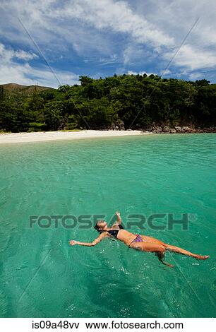 Stock Photo - Woman floating in tropical water. Fotosearch