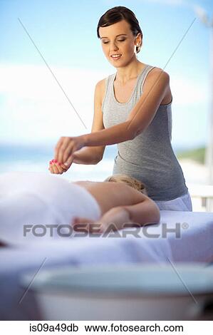 Stock Image - Woman giving salt scrub outdoors. Fotosearch