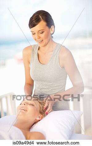 Picture - Woman giving scalp massage outdoors. Fotosearch