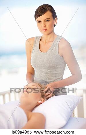 Stock Photography - Woman giving scalp massage outdoors. Fotosearch