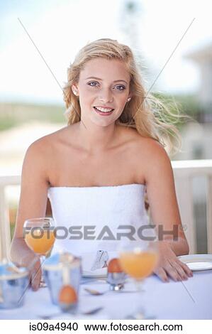 Stock Image - Woman having breakfast outdoors. Fotosearch