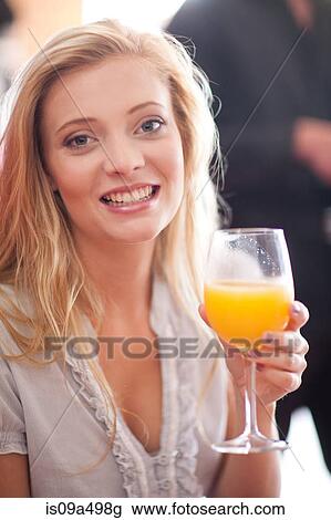 Stock Image - Woman having orange juice in cafe. Fotosearch