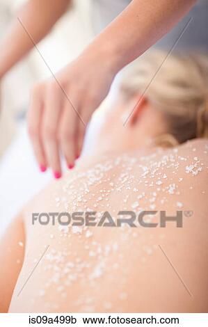 Stock Image - Woman having salt scrub on beach. Fotosearch