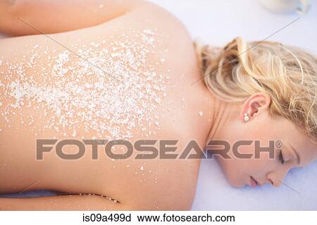 Stock Image - Woman having salt scrub on beach. Fotosearch