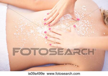Stock Image - Woman having salt scrub on beach. Fotosearch