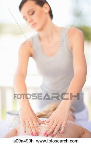 Stock Image - Woman having salt scrub on beach. Fotosearch