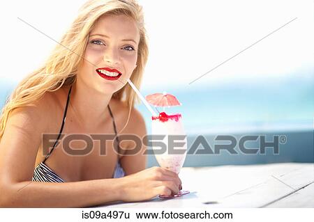 Woman having tropical drink outdoors View Large Photo Image Stock Photograph - Woman having tropical drink outdoors. Fotosearch