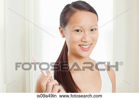 Woman holding toothbrush in bathroom View Large Photo Image Picture - Woman holding toothbrush in bathroom. Fotosearch