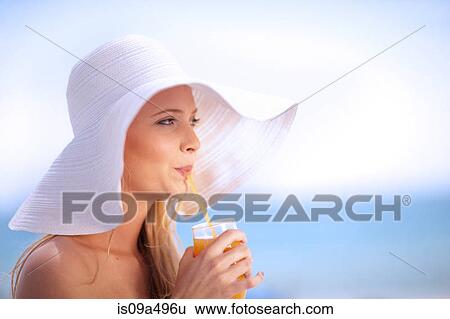 Woman in floppy hat drinking juice View Large Photo Image Stock Photograph - Woman in floppy hat drinking juice. Fotosearch