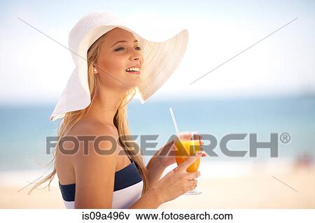 Stock Photo - Woman in floppy hat having juice. Fotosearch