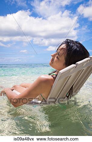 Woman in lawn chair in tropical water View Large Photo Image Stock Photo - Woman in lawn chair in tropical water. Fotosearch