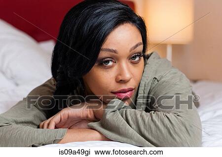 Stock Image - Woman laying on bed. Fotosearch