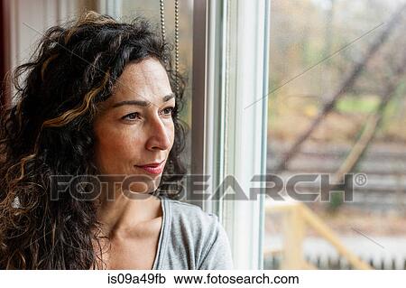Stock Image - Woman looking out window. Fotosearch