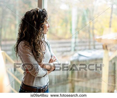 Stock Photograph - Woman looking out window. Fotosearch