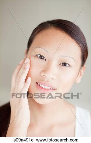 Woman moisturizing her face View Large Photo Image Stock Image - Woman moisturizing her face. Fotosearch