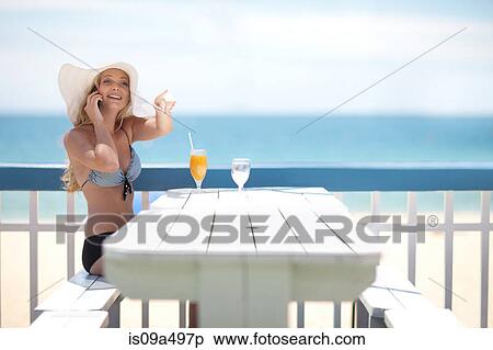 Woman on cell phone at table on deck View Large Photo Image Stock Photography - Woman on cell phone at table on deck. Fotosearch