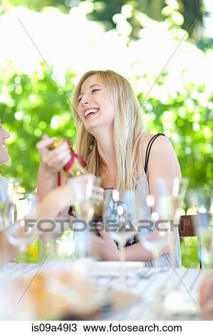 Stock Image - Woman opening presents at party. Fotosearch
