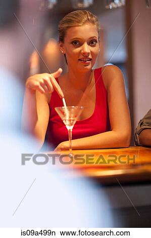 Woman ordering another drink at bar View Large Photo Image Picture - Woman ordering another drink at bar. Fotosearch