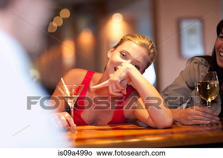 Woman ordering another drink at bar View Large Photo Image Picture - Woman ordering another drink at bar. Fotosearch