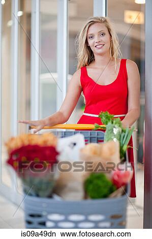 Picture - Woman pushing shopping cart. Fotosearch