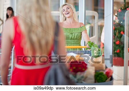 Stock Photography - Woman pushing shopping cart. Fotosearch