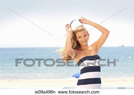 Picture - Woman putting sunglasses on head. Fotosearch