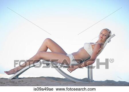 Woman relaxing in lawn chair on beach View Large Photo Image Stock Image - Woman relaxing in lawn chair on beach. Fotosearch