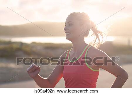 Picture - Woman running on beach. Fotosearch