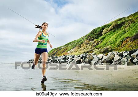 Stock Photo - Woman running on beach. Fotosearch