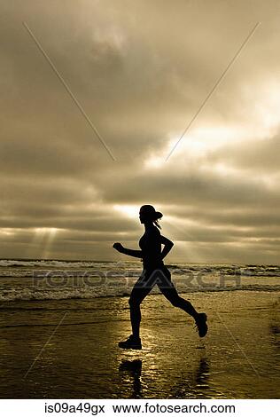 Stock Photo - Woman running on beach. Fotosearch