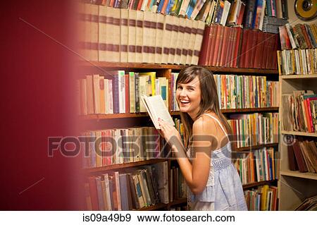 Stock Photo - Woman shopping in thrift store. Fotosearch