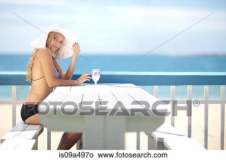 Woman sitting at table on deck View Large Photo Image Picture - Woman sitting at table on deck. Fotosearch