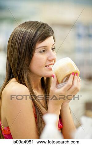 Woman smelling candle in store View Large Photo Image Stock Image - Woman smelling candle in store. Fotosearch