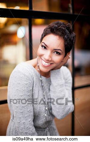 Woman smiling at window View Large Photo Image Stock Image - Woman smiling at window. Fotosearch
