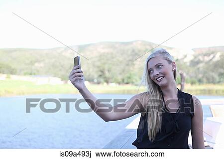 Stock Image - Woman taking picture of herself. Fotosearch