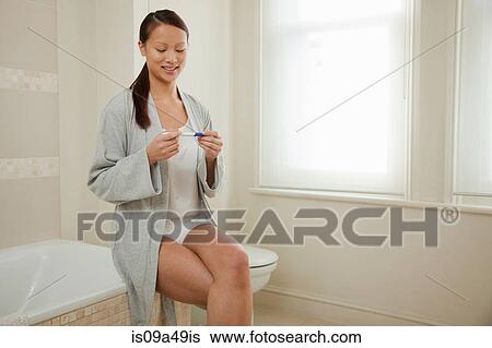 Woman taking pregnancy test in bathroom View Large Photo Image Stock Photograph - Woman taking pregnancy test in bathroom. Fotosearch