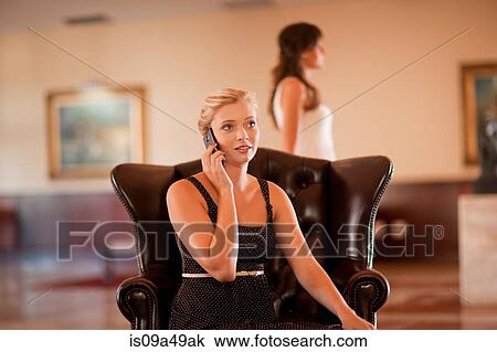 Woman talking on cell phone in lobby View Large Photo Image Stock Image - Woman talking on cell phone in lobby. Fotosearch