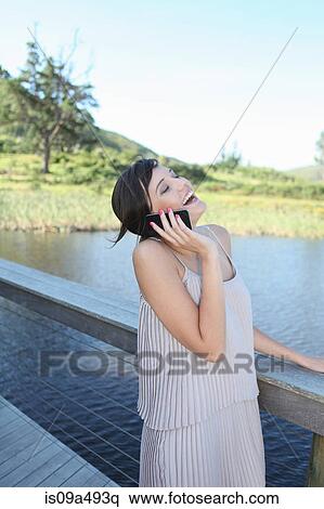 Stock Photography - Woman talking on cell phone outdoors. Fotosearch