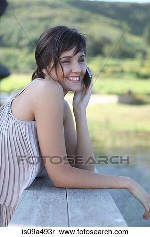 Stock Photography - Woman talking on cell phone outdoors. Fotosearch