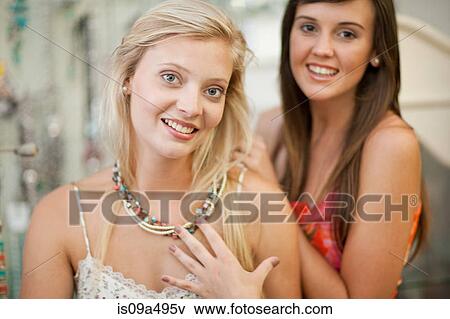 Stock Photo - Woman trying on jewelry in store. Fotosearch