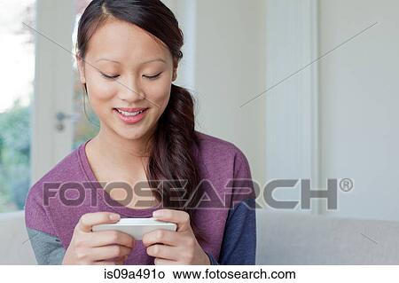Woman using cell phone on sofa View Large Photo Image Picture - Woman using cell phone on sofa. Fotosearch