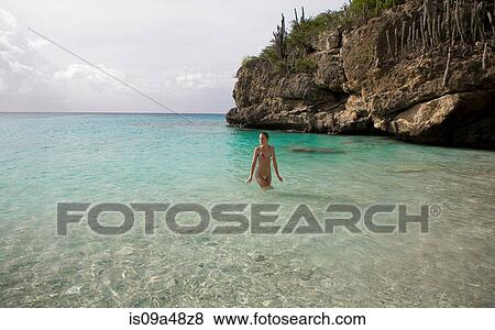 Stock Photo - Woman walking in tropical water. Fotosearch