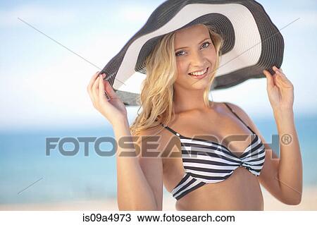 Stock Image - Woman wearing bikini and floppy hat. Fotosearch