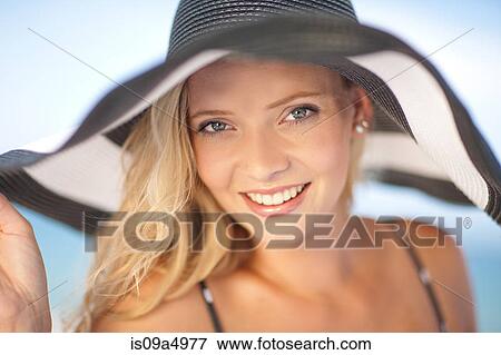 Stock Photo - Woman wearing floppy hat outdoors. Fotosearch