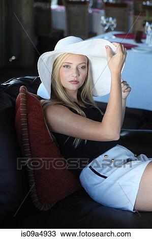 Woman wearing hat on sofa View Large Photo Image Stock Image - Woman wearing hat on sofa. Fotosearch